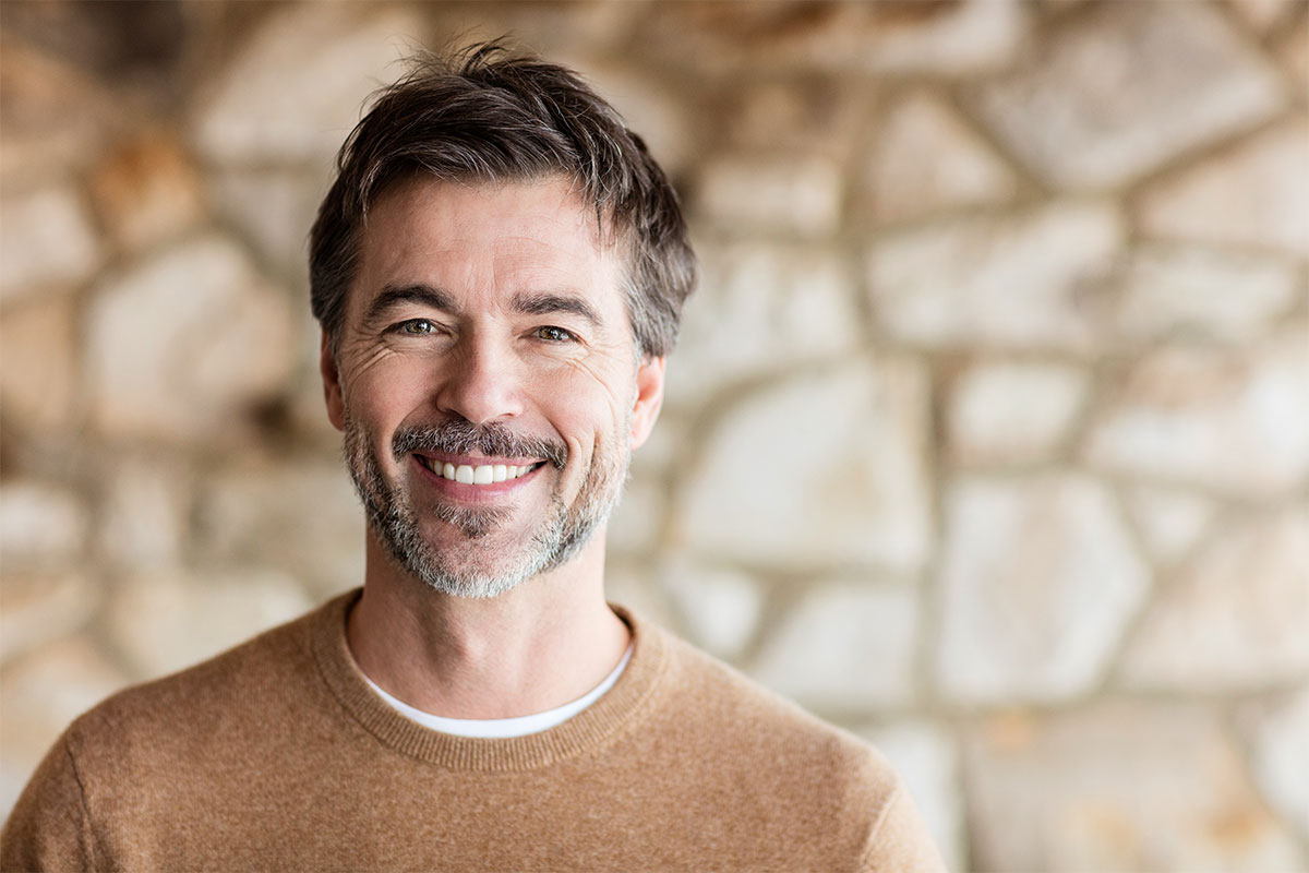Man smiling after getting porcelain veneers in Sharon.